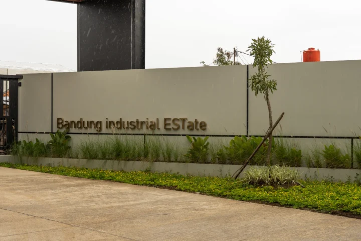 Papan nama Bandung Industrial Estate dengan taman hijau di area gerbang