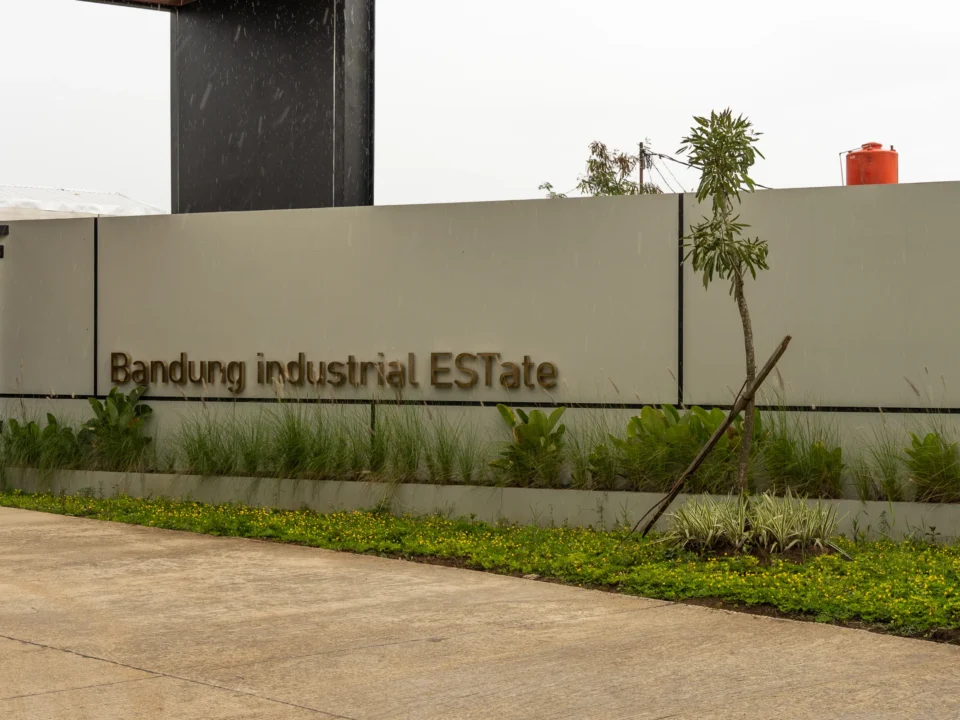 Papan nama Bandung Industrial Estate dengan taman hijau di area gerbang